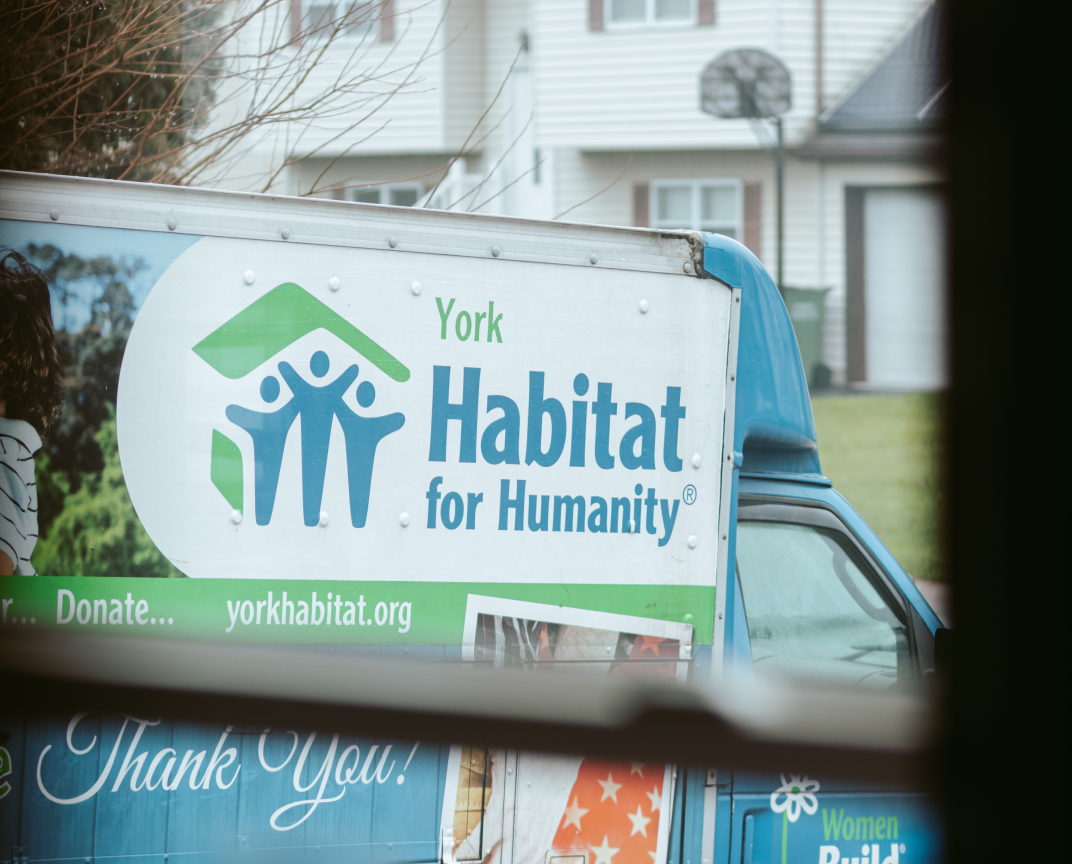 View from a window of a van with a Habitat for Humanity logo.